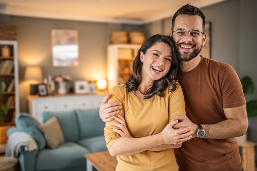 Portrait of a happy young couple in their living room at home