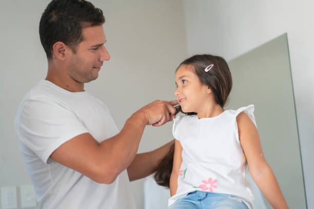 istock Father happily combing  daughter's hair at home bathroom. 1947808478