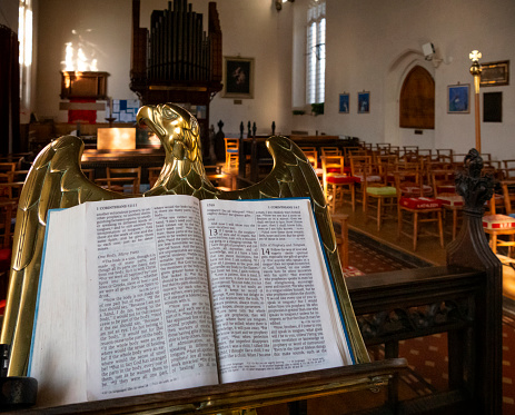 Church Choir during performance at Concert during Christmas Holiday season. Mixed age group of people dressed in all black attire. Interior of Anglican church at night.