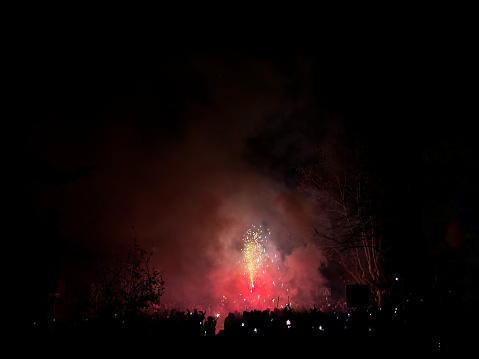 Shadows of people in devils costumes and fireworks