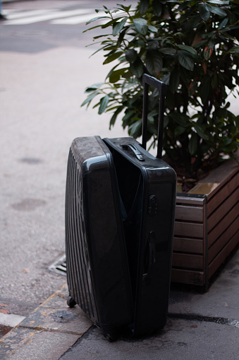 a broken suitcase that was left on the street