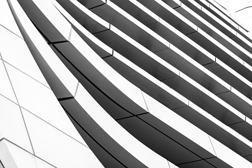 Closeup low angle view of modern corporate glass building, Sydney Darling Harbour, black and white, background with copy space, full frame horizontal composition