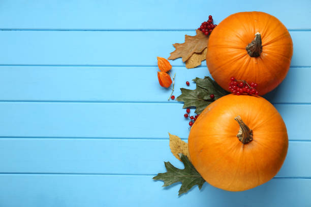 istock Thanksgiving day. Flat lay composition with pumpkins on light blue wooden table, space for text 1947964612