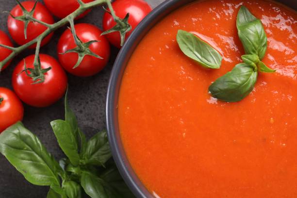 istock Delicious tomato cream soup in bowl and ingredients on grey table, flat lay 1947965231