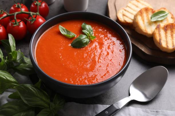 istock Delicious tomato cream soup in bowl served on grey table 1947965235