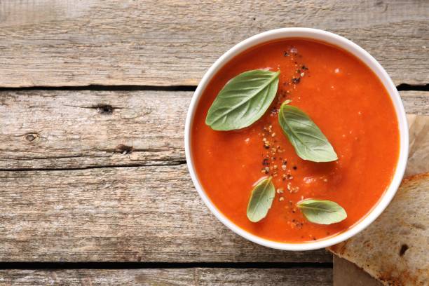 istock Delicious tomato soup with basil and spices on wooden table, top view. Space for text 1947965258