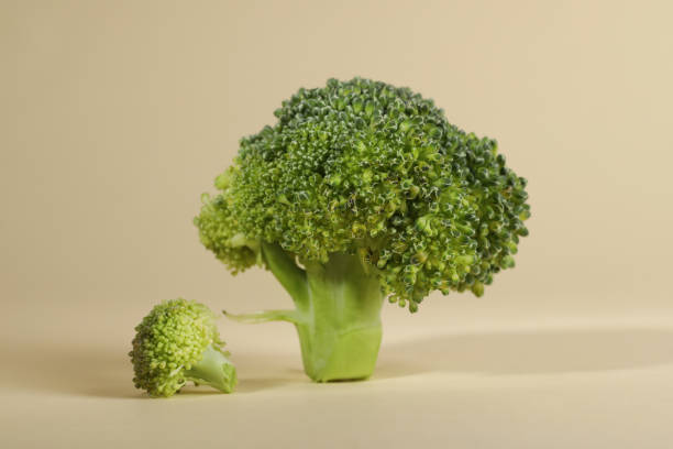 istock Fresh raw broccoli on beige background, closeup 1947965309