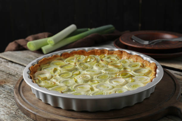 istock Tasty leek pie and raw stems on old wooden table 1947965414