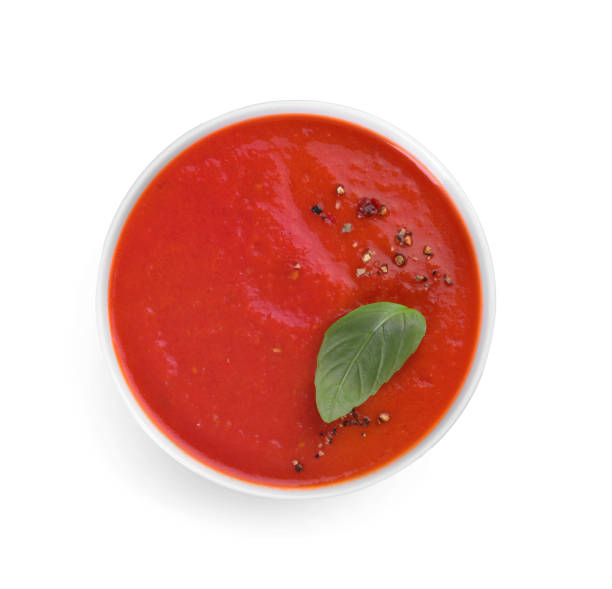 istock Delicious tomato soup with basil and spices isolated on white, top view 1947965458