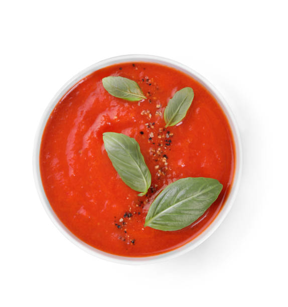 istock Delicious tomato soup with basil and spices isolated on white, top view 1947965475