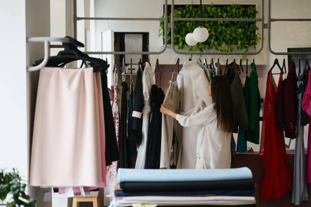 istock Seamstress examines a collection of clothes in a design studio 1947981790