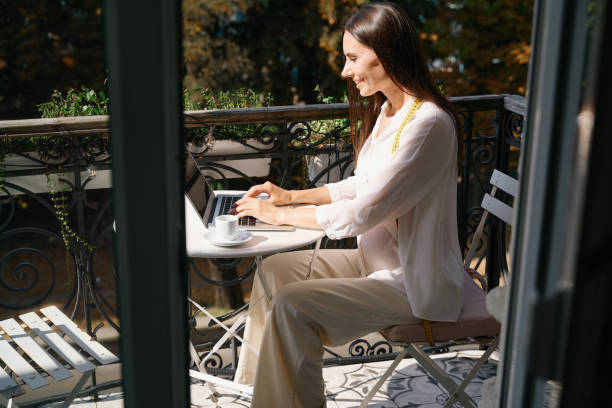 istock Craftswoman communicates online on a laptop on a charming balcony 1947982450