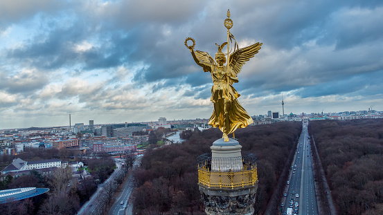 Fantastic drone point of view on Victory column,  sunbeams of sunset, Tiergarten of Berlin and Bundesstrasse 2 leads to downtown.  There is observation desk on Column. At left Office of Federal PresidentSpree river, also Anne Frank school.