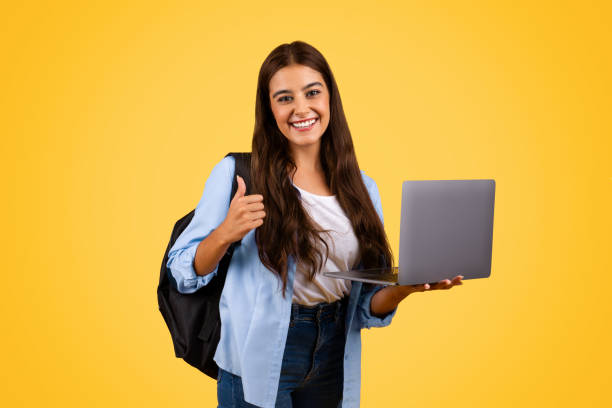 istock Glad pretty caucasian young student lady use laptop, show thumb up gesture 1948014624