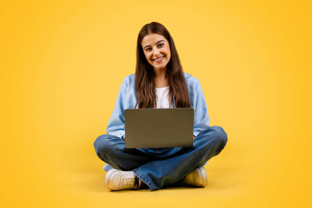 istock Positive caucasian young student lady use laptop, typing, work and sit on floor 1948014634