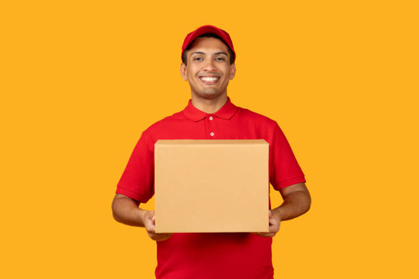 istock Mexican Delivery Man Holding Box Giving Parcel Over Yellow Background 1948033318
