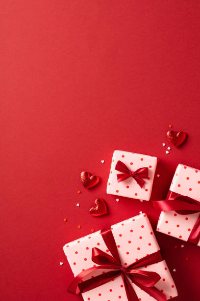 istock Valentine's Day background. Gift boxes with red ribbon bows, hearts, confetti on red background. Valentines day concept. Flat lay, top view, copy space 1948079233