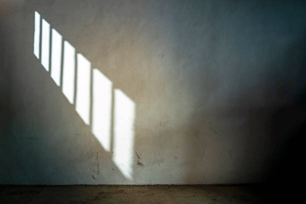 OLD DARK CELL IN JAIL OR PRISON WITH SUNLIGHT COMING THROUGH THE BARRED WINDOW. OLD DARK CELL OR DUNGEON IN JAIL OR PRISON WITH SUNLIGHT COMING THROUGH THE BARRED WINDOW. PRISONER SERVING SENTENCE. judgement free stock pictures, royalty-free photos & images
