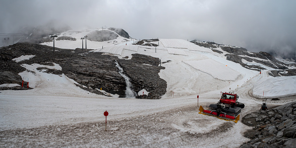 A large snow tarpaulin protecting the ice of the Hintertux glacier in the Alps, a ski slope is leading in between, Austria