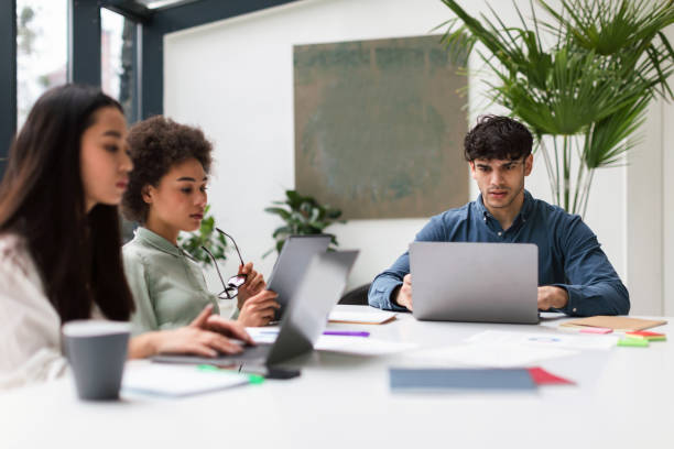 istock Multicultural team working together in office, sitting at laptops 1948113142
