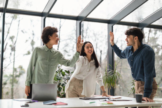 istock Multicultural Colleagues Team Celebrates Achievement with High Five In Office 1948113154