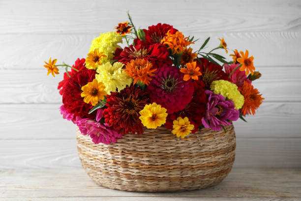 istock Beautiful wild flowers in wicker basket on light wooden table 1948128752