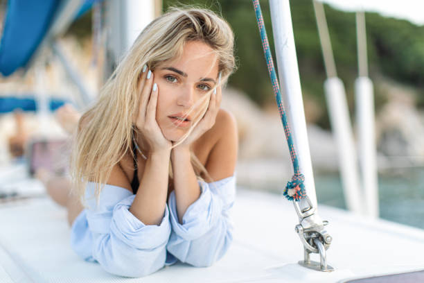 a beautiful young woman lying on a boat deck - sailing light wind nautical vessel imagens e fotografias de stock