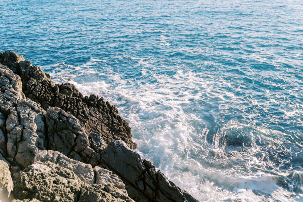 istock Blue sea foams hitting the rocky high shore 1948134466