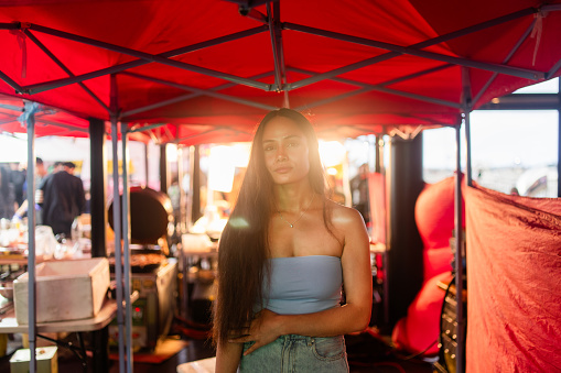 The portrait of modern woman with long hairs out in market looking at camera.