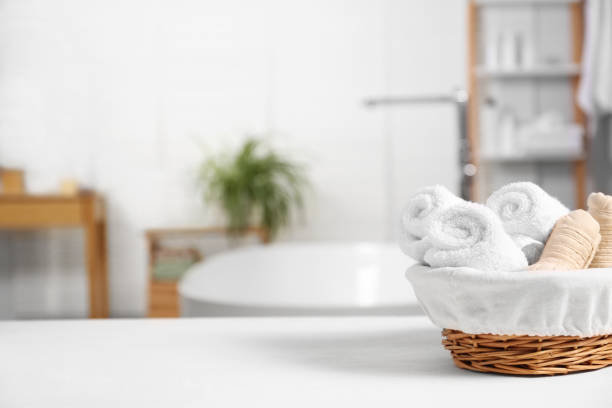 istock Basket with spa herbal bags and towels on white table in bathroom, space for text 1948192291