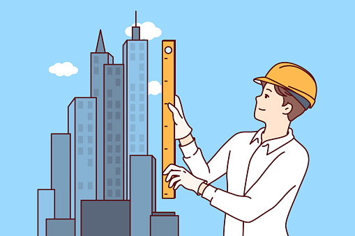 Man architect designs construction of skyscraper and stands near models of downtown holding ruler in hands. Guy works as engineer in construction business, creating architectural plan for new project