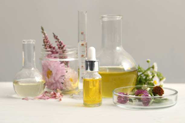 istock Cosmetic oil, laboratory dishware and flowers on white table 1948194432