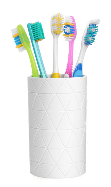 istock Different toothbrushes in holder isolated on white 1948195485