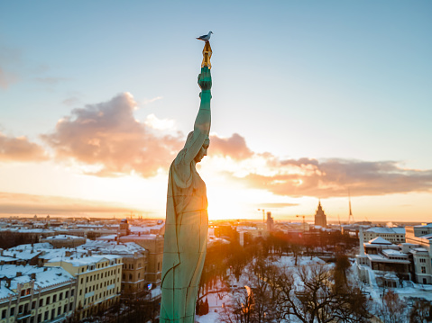 Beautiful sunset view over Riga by the statue of liberty - Milda in Latvia. The monument of freedom.