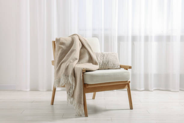 istock Comfortable armchair with blanket and pillow in room 1948204511