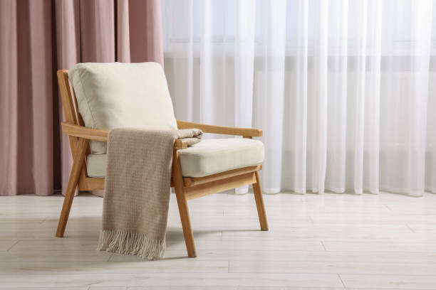 istock Comfortable armchair with blanket in room, space for text 1948205003