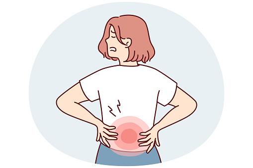 Woman stands with back to screen and holds on to red lower back after failing to lift heavy bag. Girl suffers from pain in spine needs massage or help of osteopath doctor. Flat vector illustration