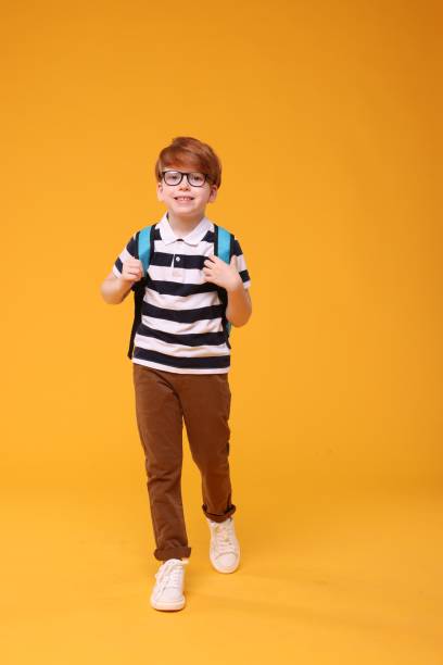 istock Happy schoolboy in glasses on orange background 1948251504