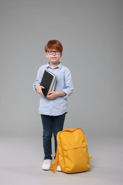 istock Happy schoolboy with books on grey background 1948255781