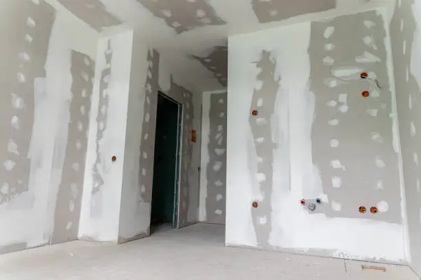 Interior of a house under renovation with drywall installation and joint compound application