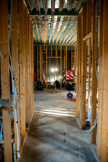 Under-construction home interior with wooden framing, electrical wiring, and ladder on site