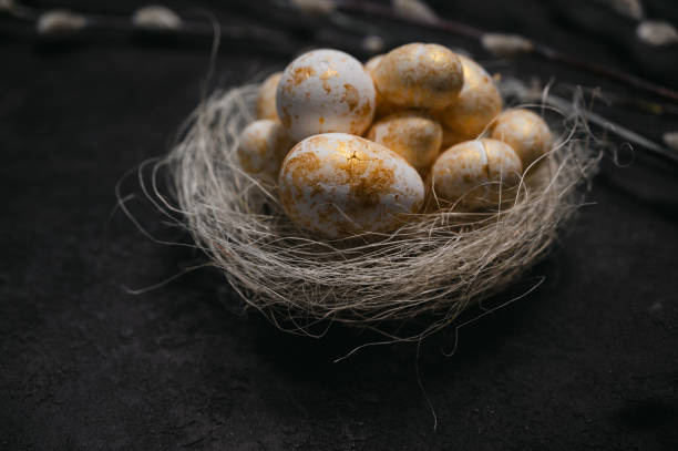 istock golden and white eggs in the nest on black rustic background 1948356780