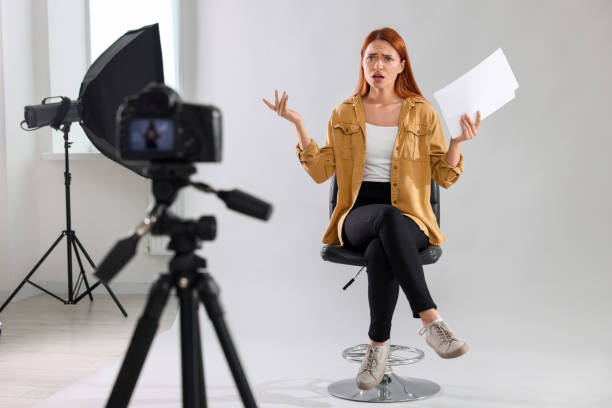 istock Casting call. Emotional woman with script performing in front of camera against light grey background at studio 1948360932