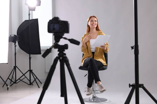 istock Casting call. Woman with script performing in front of camera against light grey background at studio 1948360934