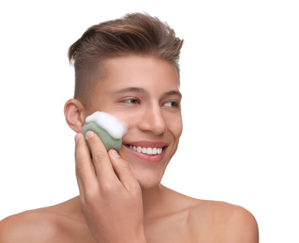 istock Happy young man washing his face with sponge on white background 1948414084