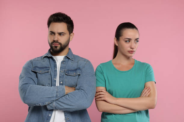 istock Resentful couple with crossed arms on pink background 1948443618
