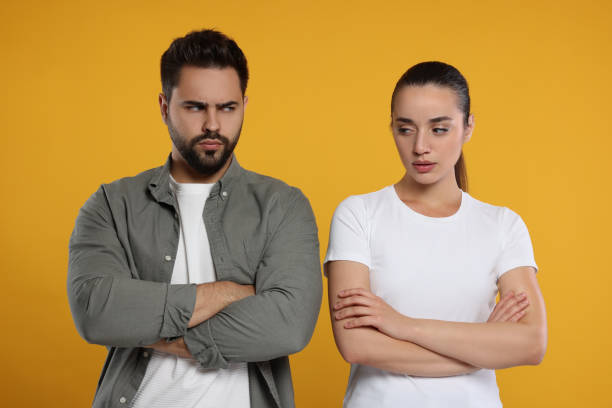istock Resentful couple with crossed arms on orange background 1948443626