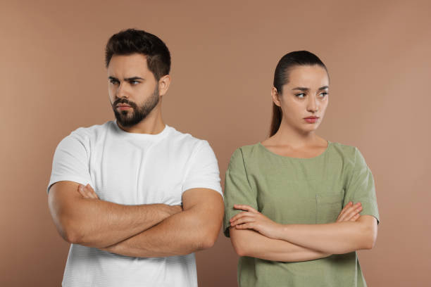 istock Resentful couple with crossed arms on brown background 1948443627