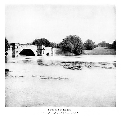 Blenheim Palace view from the lake, Woodstock, Oxfordshire, England, is the seat of the Dukes of Marlborough. Blenheim is the birthplace and ancestral home of Sir Winston Churchill. Photograph engraving published 1896. This edition is in my private collection. Copyright is in public domain.