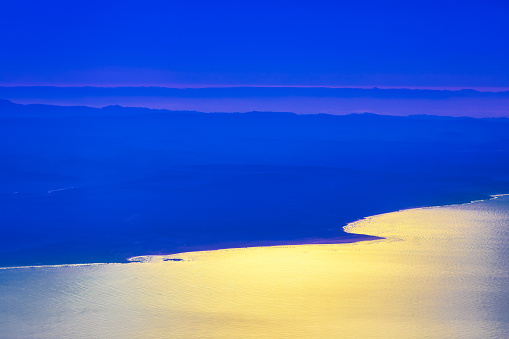 Atlantic coast of Morocco view from above. Aerial view of ocean and mountains at sunset.